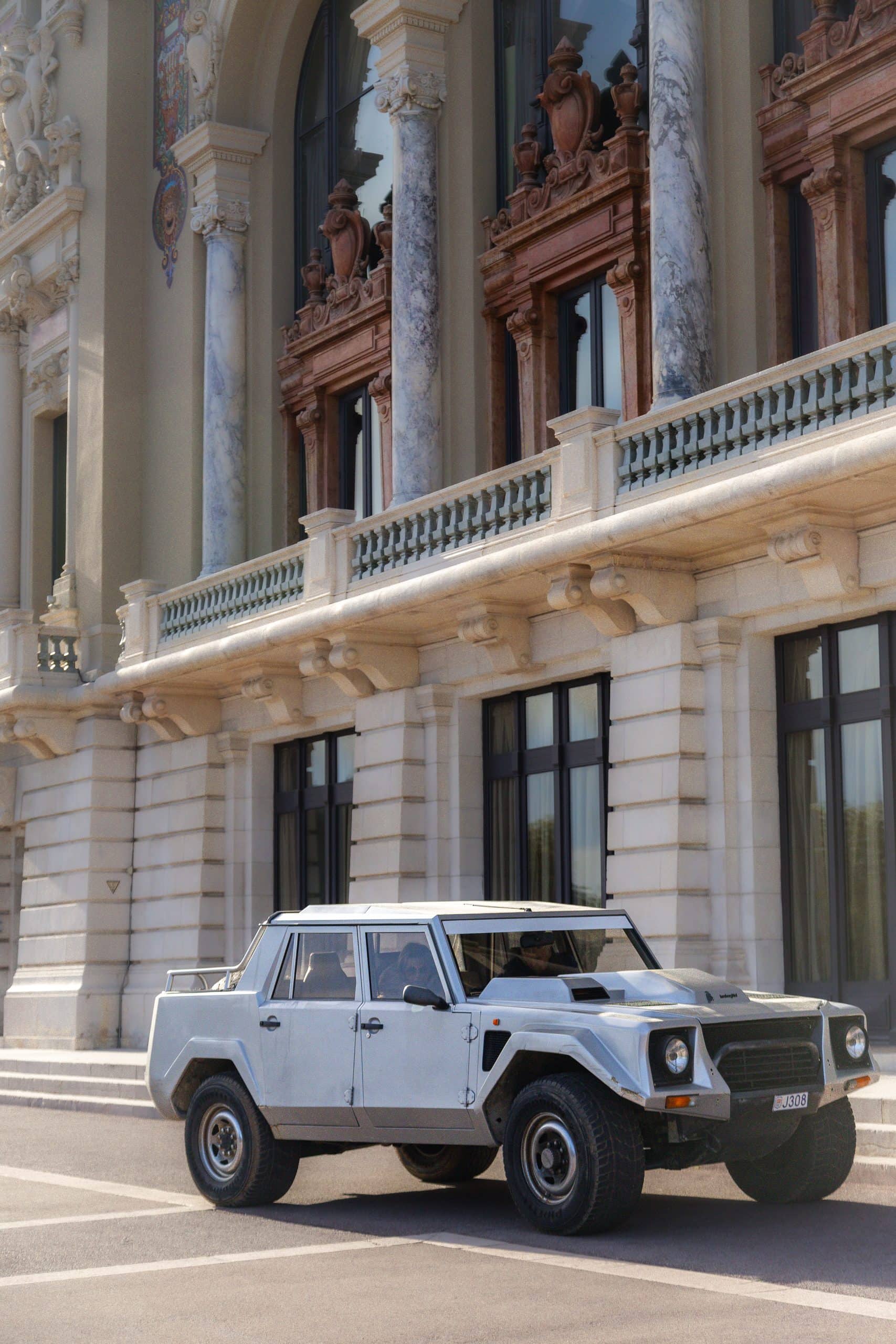 A white off-road icon positioned in front of a grand architectural facade.