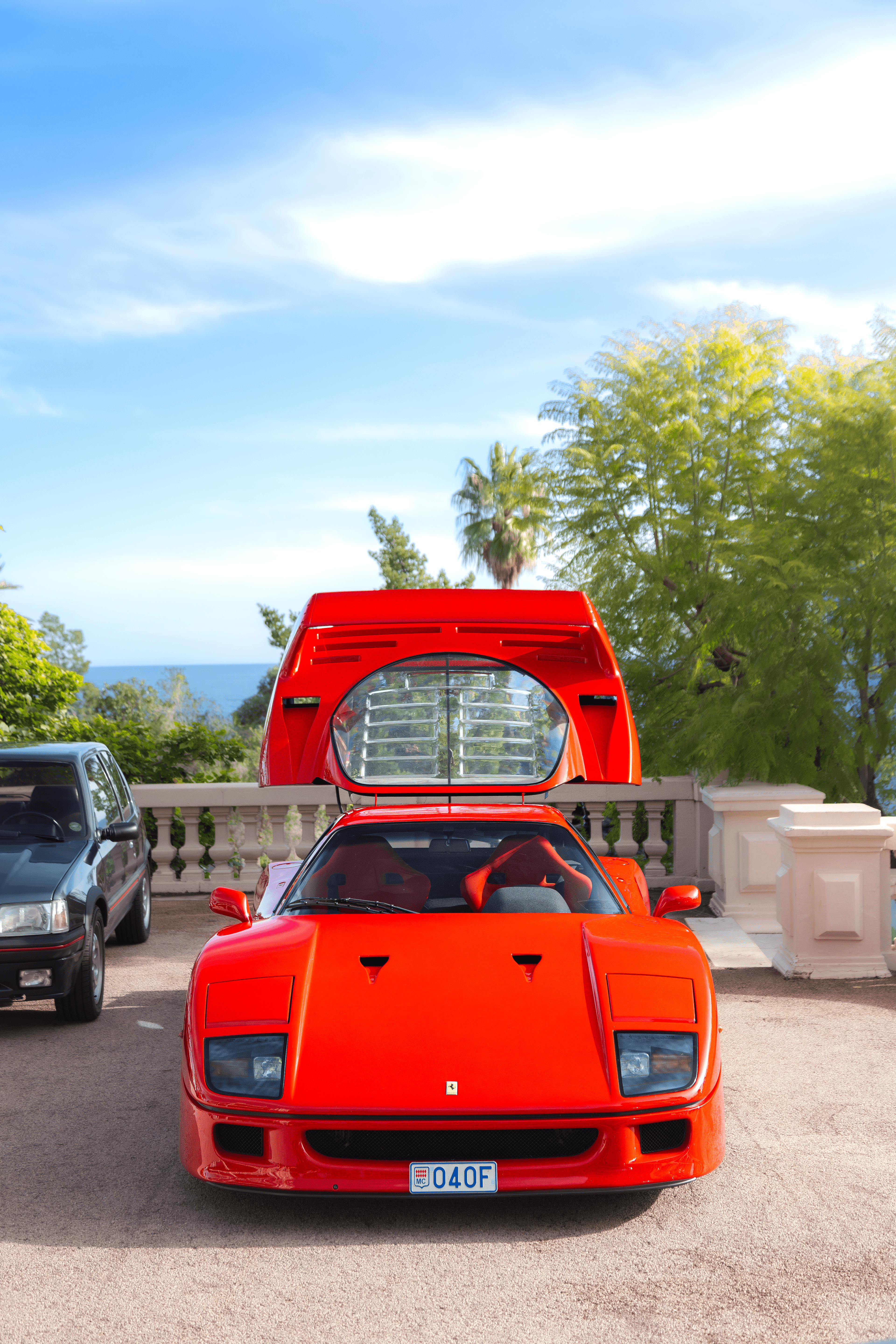 A red supercar with one door raised in a portrait-oriented composition.
