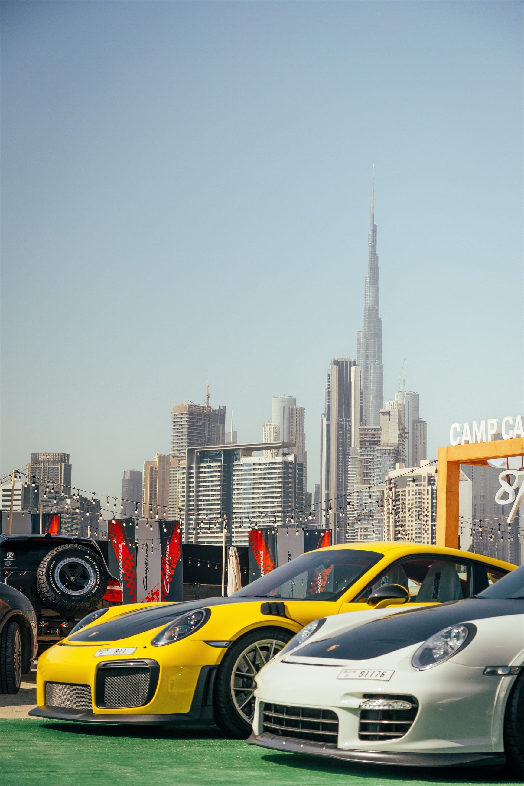 Two Porsche 911 GT models side by side, the Burj Khalifa behind them.