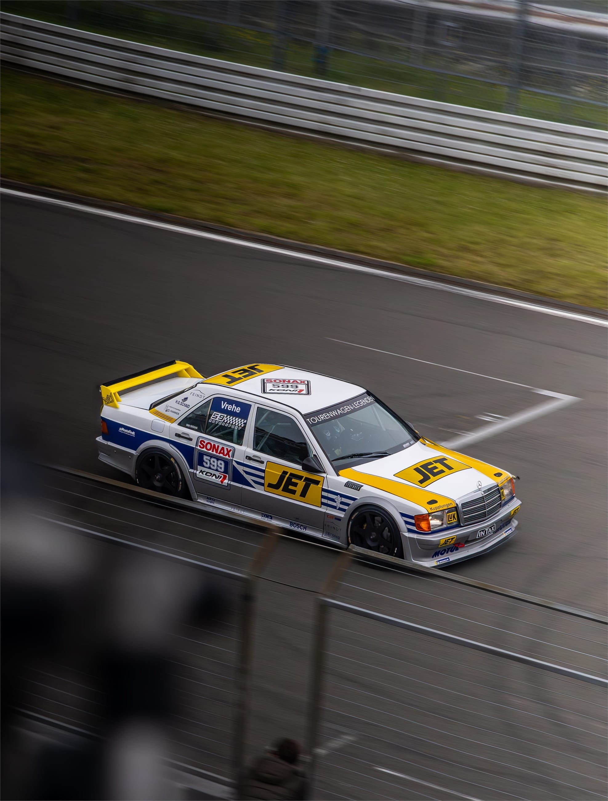 White and yellow classic touring saloon cornering on a wet track.