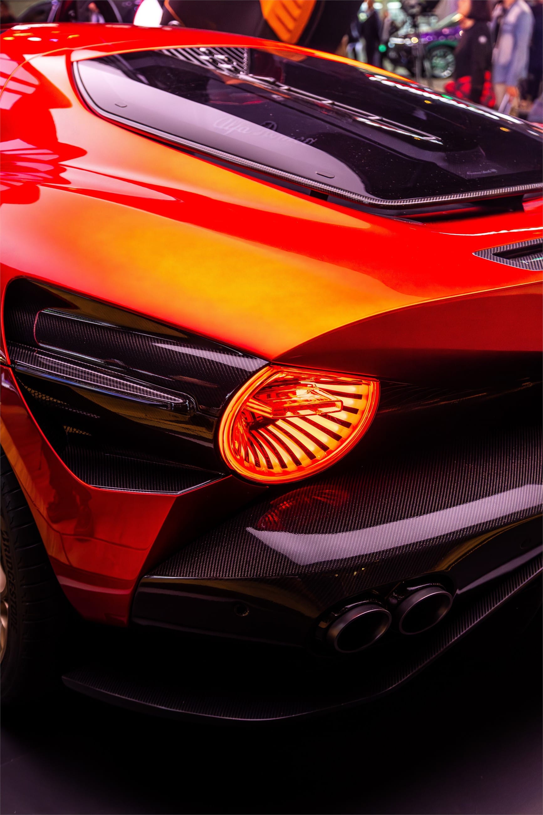 The coupe's tail light and rear grille, glowing in low light.
