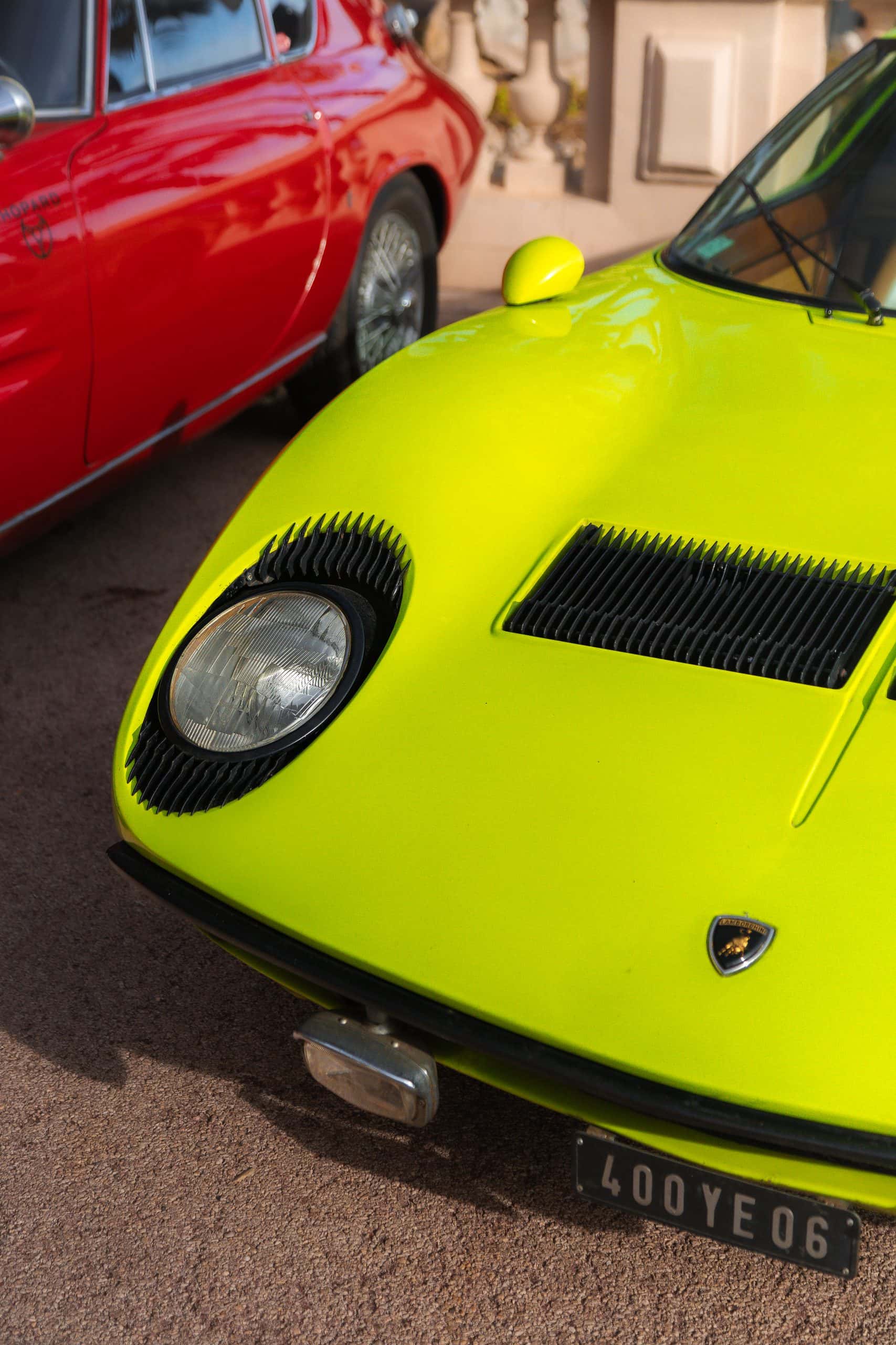 A tight front-end study of an acid green sports car with strong contrast.